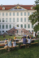 Besucher:innen auf der Wiese vor dem Waisenhaus